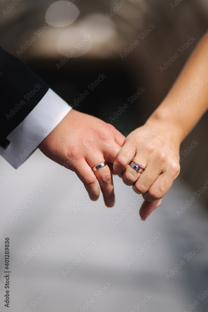 Obraz premium Hand of bride and groom hold each other. Close-up