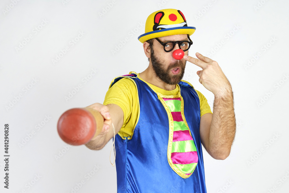The clown is a man in a bright blue and yellow suit with a baseball bat. The clown is a man in a bright blue and yellow suit with a baseball bat.