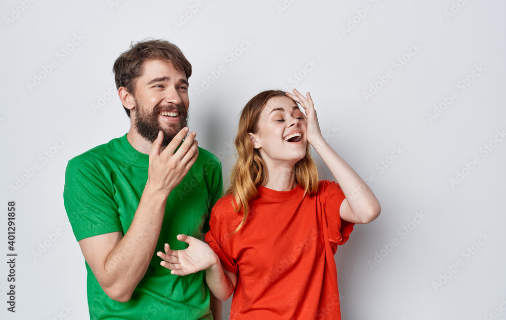 young cheerful couple emotions multicolored t-shirts studio isolated background young cheerful couple emotions multicolored t-shirts studio isolated background