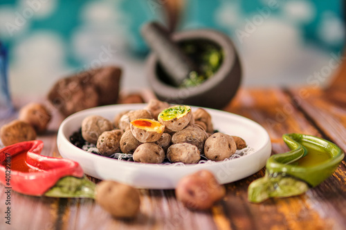 From above of tasty potatoes with wrinkly peel in plate on black beans on wooden table photo