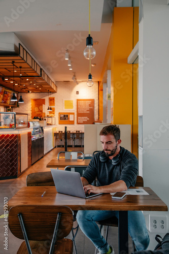 young boy working with laptop in coffee shop
