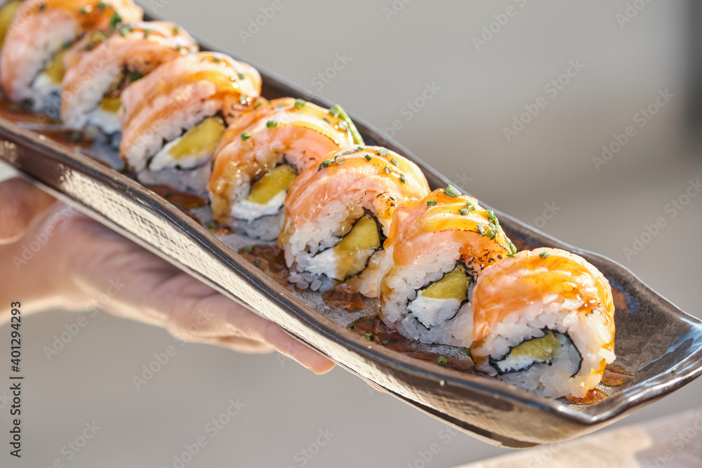 High angle of sets of assorted sushi rolls served on table in Asian restaurant High angle of sets of assorted sushi rolls served on table in Asian restaurant