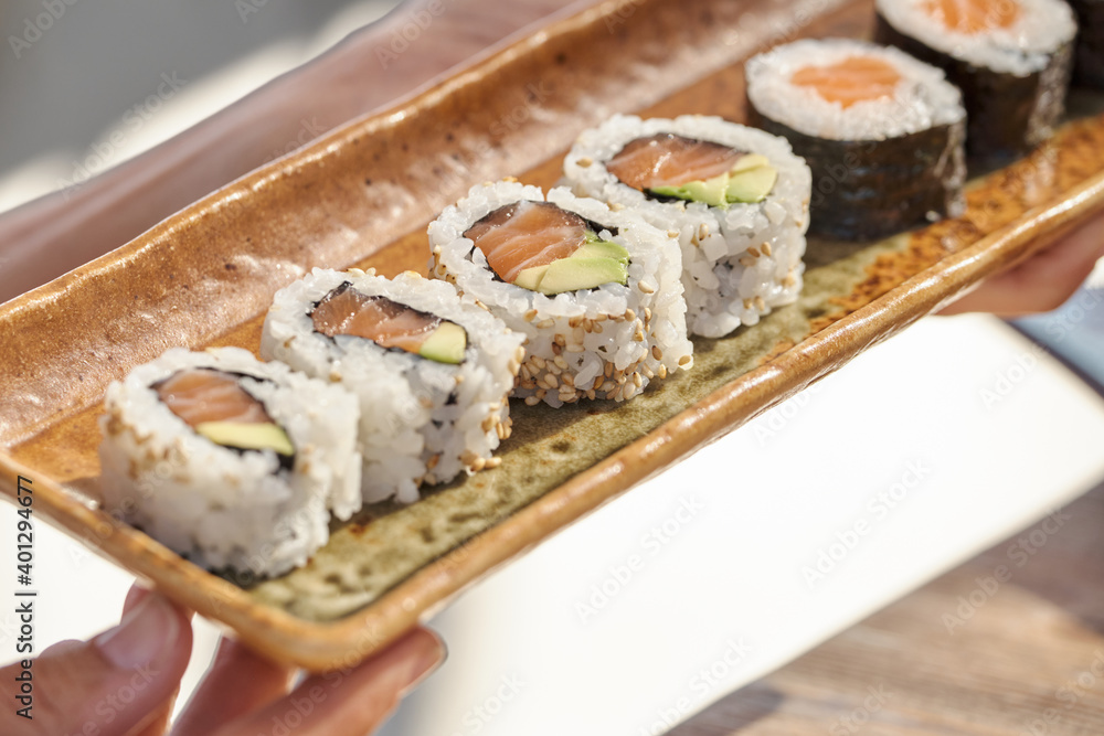 High angle of sets of assorted sushi rolls served on table in Asian restaurant High angle of sets of assorted sushi rolls served on table in Asian restaurant