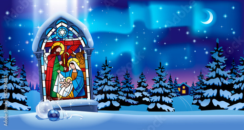 Illuminated stained glass window with Christmas scene in gothic frame against the night winter spruce forest in snow under starry sky