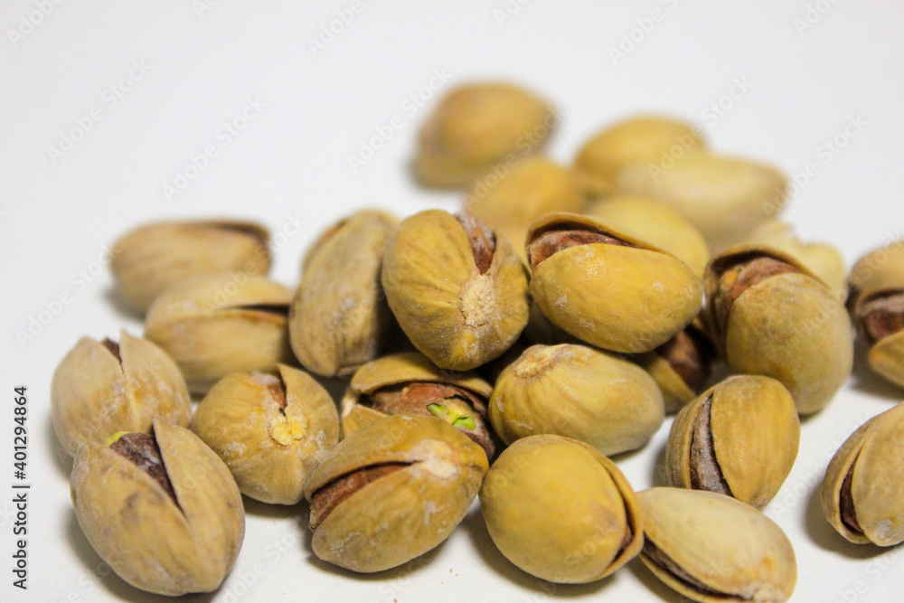 a handful of pistachios that lie on a white background a handful of pistachios that lie on a white background