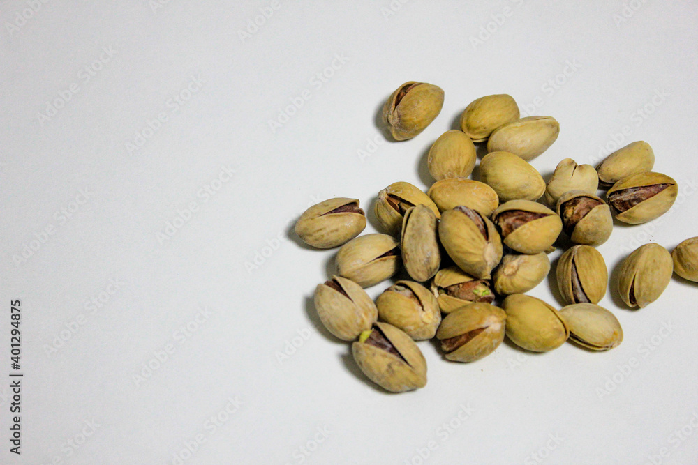a handful of pistachios that lie on a white background a handful of pistachios that lie on a white background