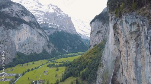 Scenery view of the waterfall of Lauterbrunnen in Switzerland with snowy mountains in background.