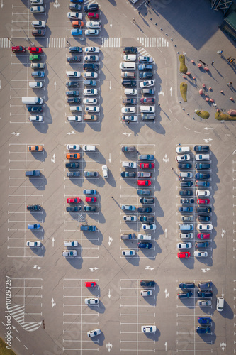 Rows on the cars on a large parking lot near the supermarket - the end of the quarantine concept. Parking near a supermarket. Drone overhead top view magazine format shot. 