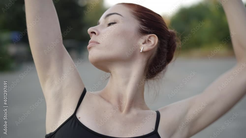 Slim confident ballet woman performing outdoors. Camera moves up along slender Caucasian ballerina moving hands. Performance and choreography concept. Slim confident ballet woman performing outdoors. Camera moves up along slender Caucasian ballerina moving hands. Performance and choreography concept.