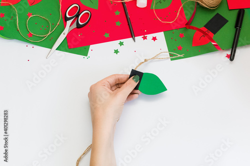 How easy and quick make paper Christmas red and green light bulb garland to decorate room or tree with children at home. Step by step instructions. Step 8. Glue bulb between the papers