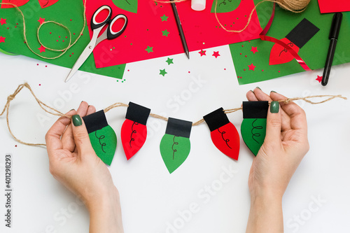 How easy and quick make paper Christmas red and green light bulb garland to decorate room or tree with children at home. Step by step instructions. Step 10. Make some light bulbs and use ready garland