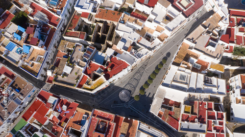 Aerial top view of typical Andalusian town in south Spain in christmas. Conil de la Frontera seen from a drone view with christmas tree in the town square. Red rooftops and white buildings from above.
