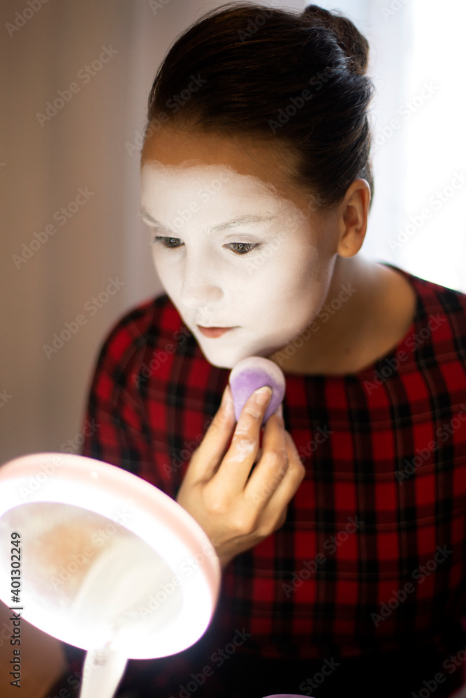 girl mime sponge applies white powder on her face girl mime sponge applies white powder on her face