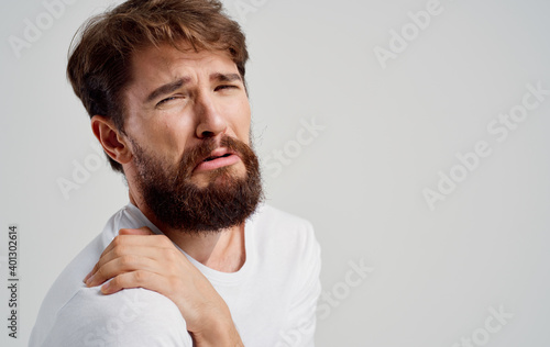 bearded man touching shoulder with hand pain dislocation