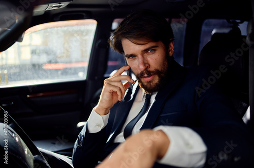 successful young man in suit talking on the phone wealth official