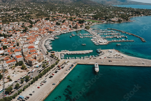 Beautiful aerial shot showing port of Aegina Island with docking ships during sunny day in Greece