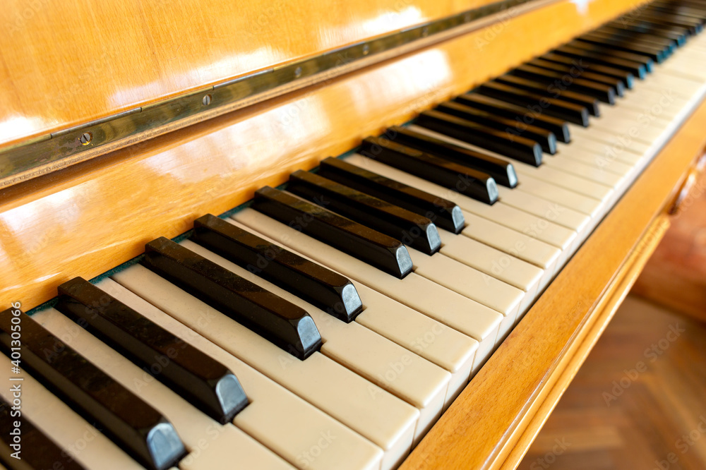 Black and white piano keys are located from left to right close up. Black and white piano keys are located from left to right close up.