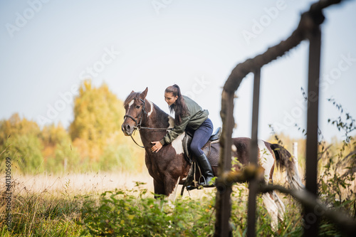 On a warm autumn day, a young girl went out to ride her mare on horseback around the farm. © Anna Kosolapova