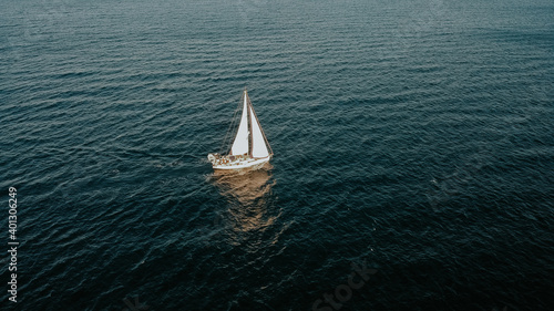  Aerial shot of lonely sailing boat at holiday on Saronic Gulf during sunset in Greece. © eVEN