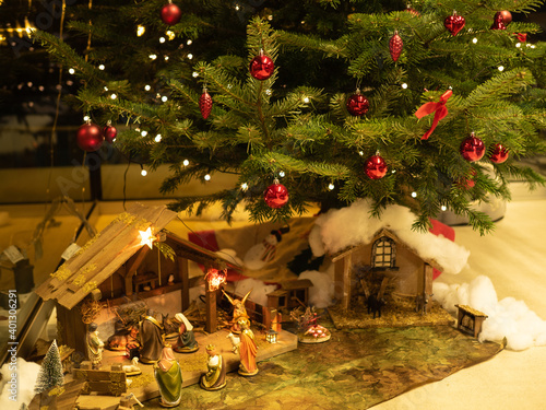 Christmas composition. Creche in front of christmas tree. Perspective view.