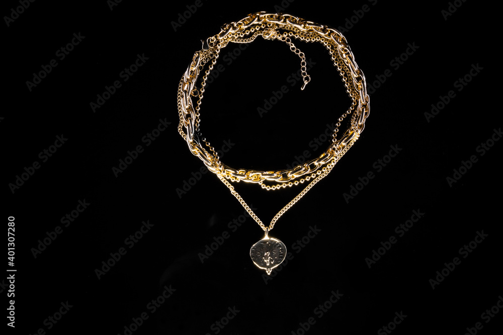 Golden jewelry chain with medallion isolated on black background Golden jewelry chain with medallion isolated on black background