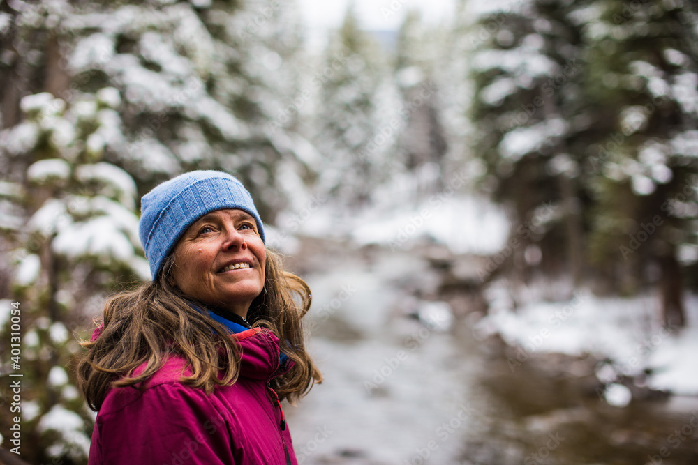 A portrait of a woman , in the winter, near Gore Creek in Vail, Colorado, USA A portrait of a woman , in the winter, near Gore Creek in Vail, Colorado, USA
