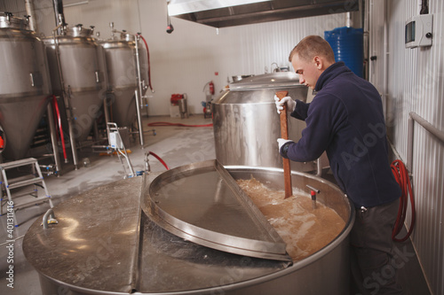 Professional brewer working at automated microbrewery  copy space