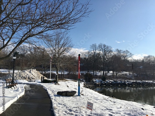 Winter scene, park, river, snow, blue sky, bare trees
