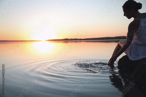 Woman near river on sunset. Healing concept © New Africa