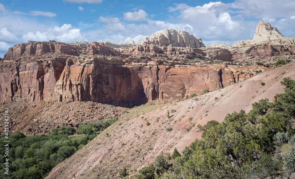 Fototapeta premium Golden sandstone geographical formations with a desert prairie landscape on a hot summer day at the Cohan Canyon Trail in Capitol Reef National Park Southern Utah.