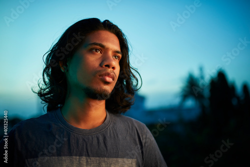 Young man portrait with long hair in evening light © krishna