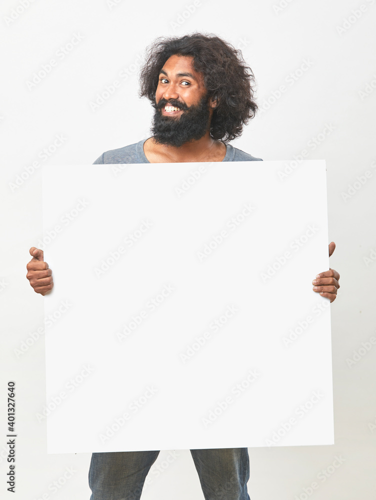 Cheerful bearded young man holding white board on white background. Cheerful bearded young man holding white board on white background.