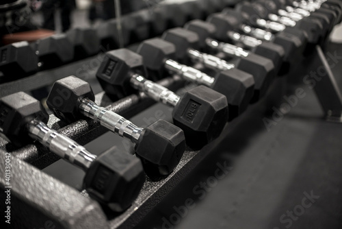 A rack of rubberized hex dumbbells at a gym or fitness club. Workout and pyramid training or running the rack concept.