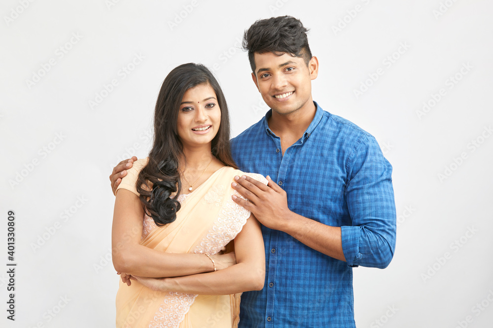 Cheerful Indian young couple in traditional outfit against white. Cheerful Indian young couple in traditional outfit against white.