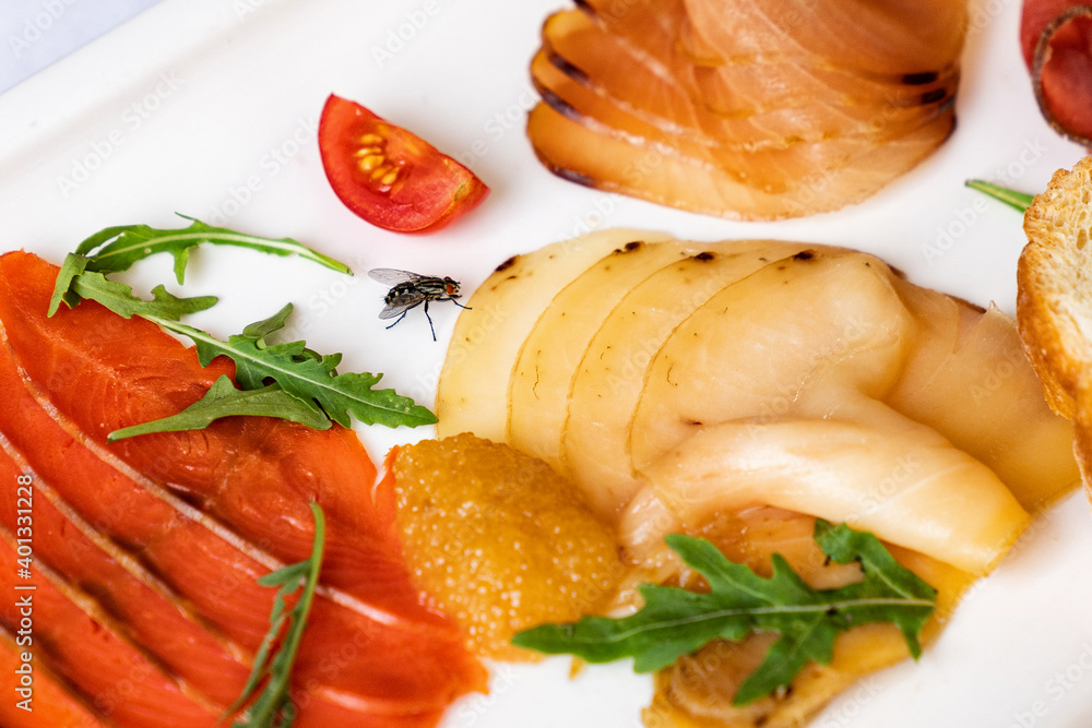assorted salted fish on white plate. snacks on holiday table. assorted salted fish on white plate. snacks on holiday table.