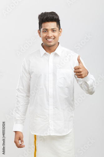 Photography Cheerful handsome south Indian man showing thumbs up on white.