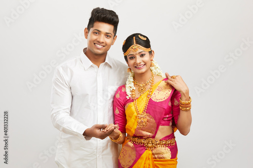 Canvas Print Attractive happy south Indian couple in traditional dress on white