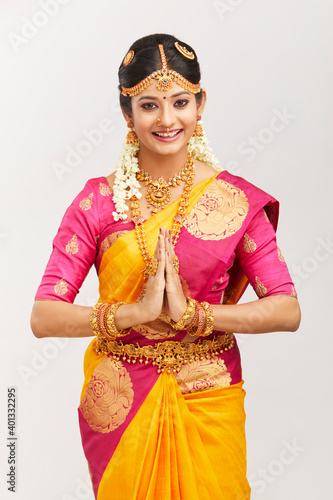 Photography Attractive smiling Indian bride with jewelry in namaste position