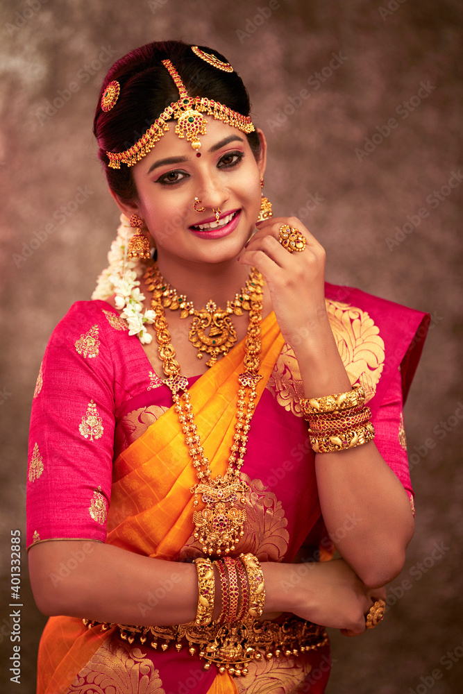 Obraz premium Beautiful smiling Indian bride with jewelry in studio shot.