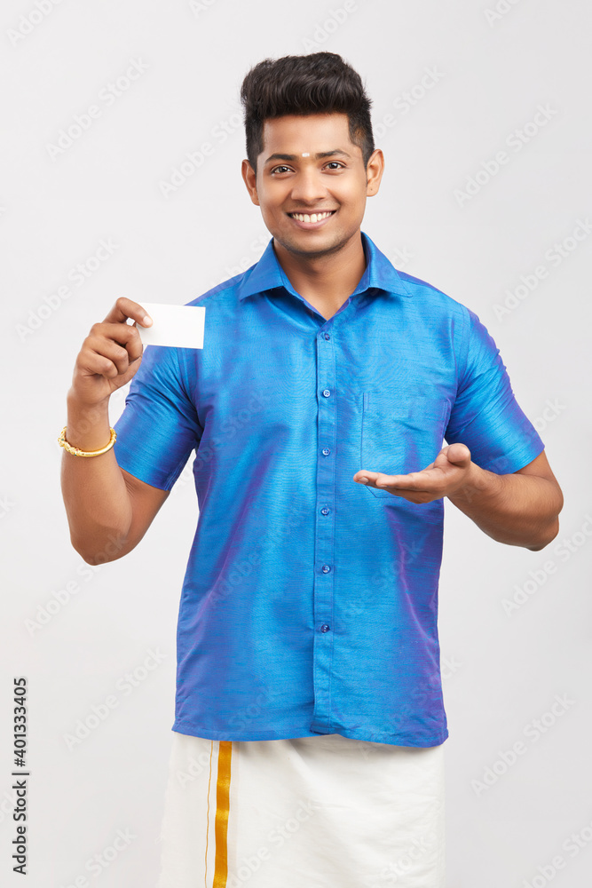 Young man holding business card in traditional dress.