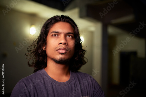 Canvas Print Young man portrait with long hair in evening light