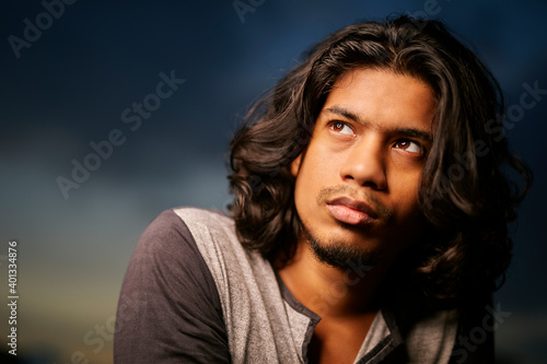 Young man portrait with long hair in evening light © krishna