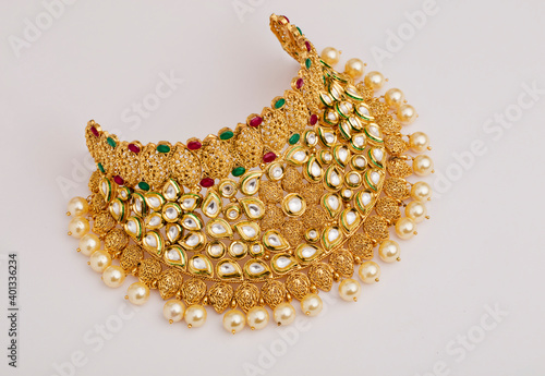 Photography Indian traditional gold necklace with stones on white.