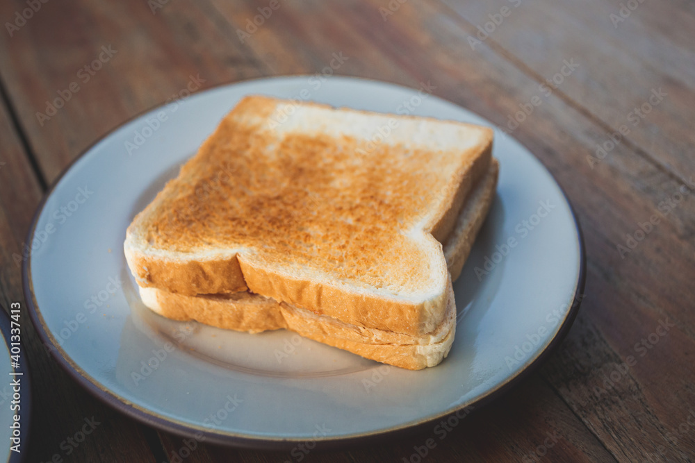 Toasts bread on a white dish on a wooden floor