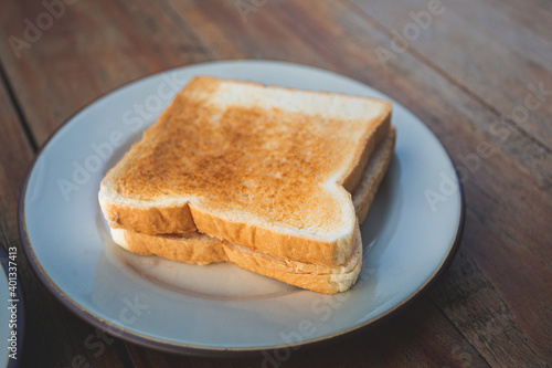 Toasts bread on a white dish on a wooden floor