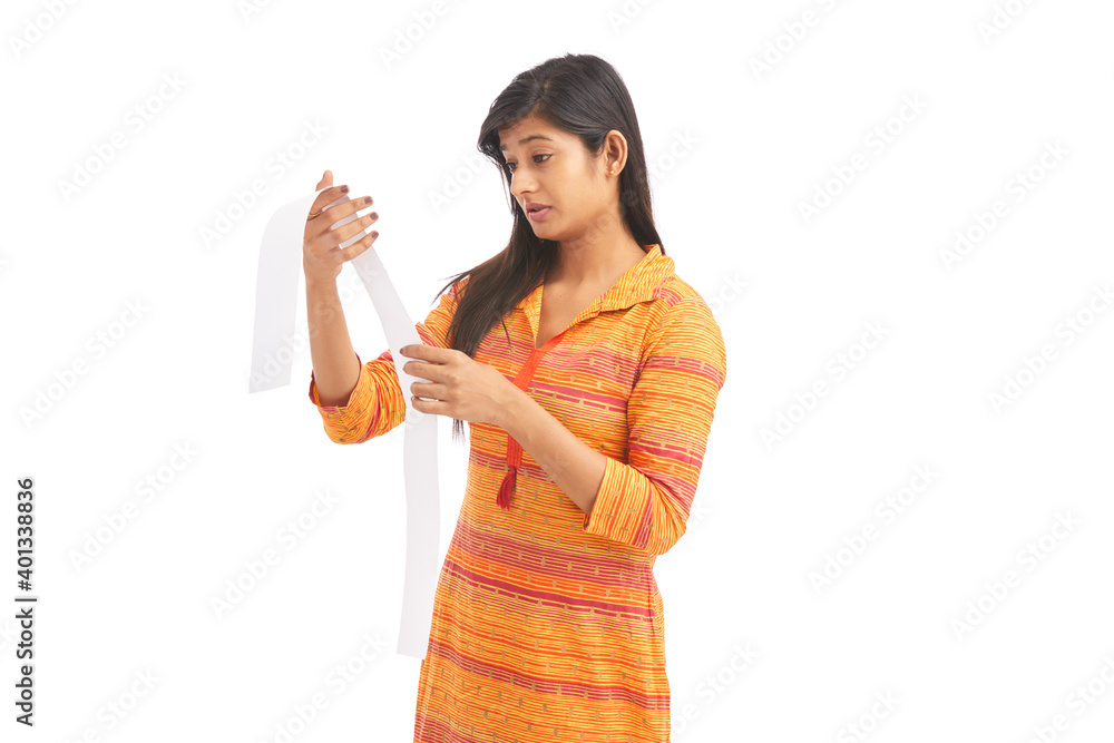 Shocked young woman looking at a store receipt on white. Shocked young woman looking at a store receipt on white.