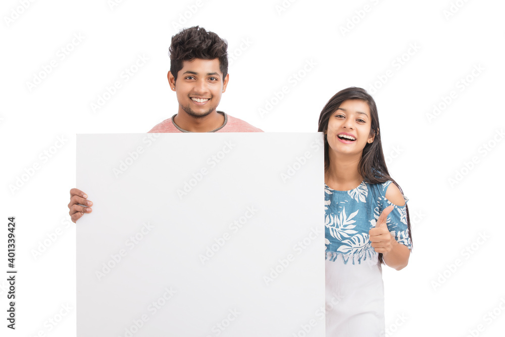 Cheerful young couple holding billboard on white background. Cheerful young couple holding billboard on white background.