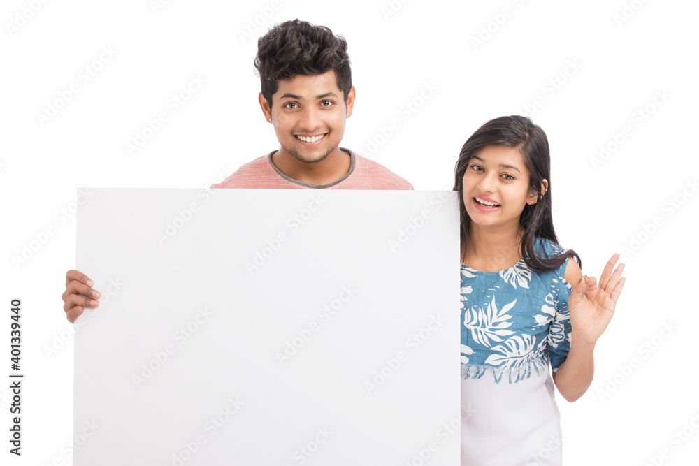 Cheerful young couple holding billboard on white background. Cheerful young couple holding billboard on white background.