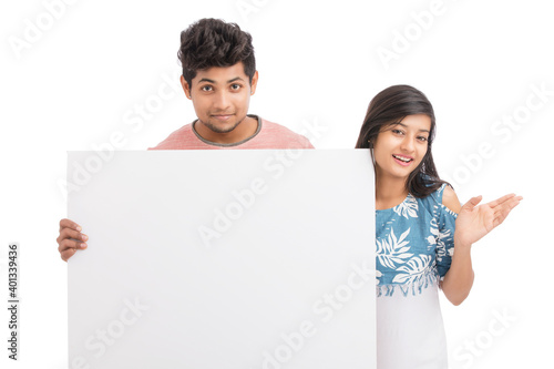 Photography Cheerful young couple holding billboard on white background.