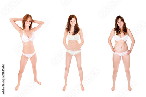 Full length portraits of three smiling women wearing white underwear, isolated on white studio background